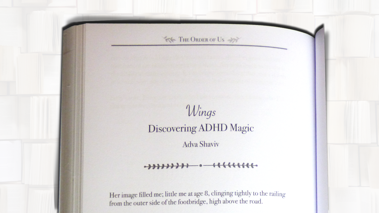 A book page with the book's name: The Order of Us; the piece's title: Wings - Discovering ADHD Magic by Adva Shaviv; and the first two lines: Her image filled me; little me at age eight, clinging tightly to the railing from the outer side of the footbridge, high above the road.